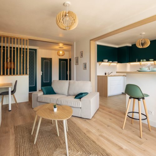 Architecte d’intérieur – rénovation d’un salon ouvert sur cuisine avec claustra bois et mur vert – Agence Planforêt